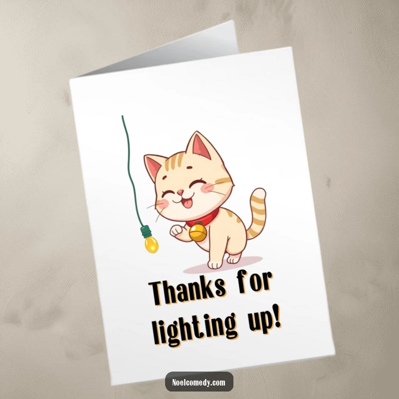 Funny Free Printable Thank You Card: A smiling cat with a bell collar chases a Christmas light, making a humorous and charming thank you.
