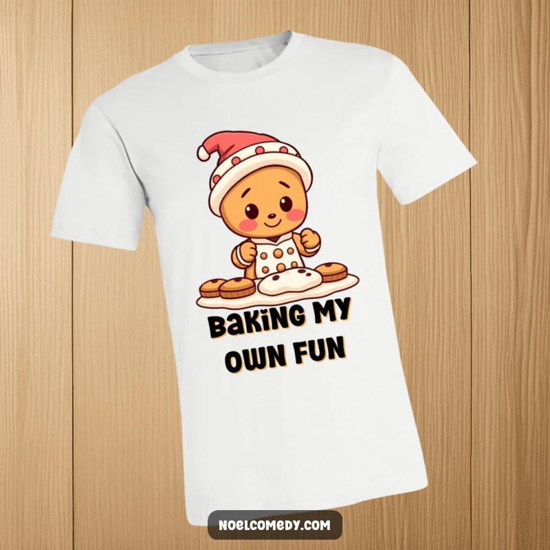 Funny t-shirt depicting a small gingerbread man wearing an oversized, comical hat, actively baking a batch of delicious cookies.